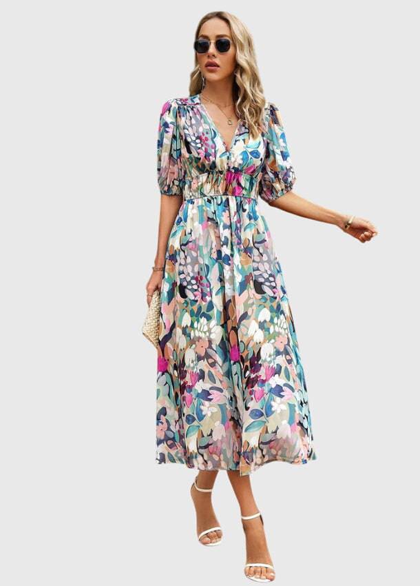 Flattering floral midi dress by THE WHITMORE FAMILY featuring a fitted waist, flowing skirt, and vibrant flower print.