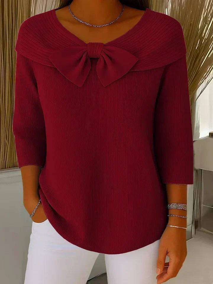 Women's sweater by THE WHITMORE FAMILY featuring a bow detail and round neckline, made of soft knit fabric.