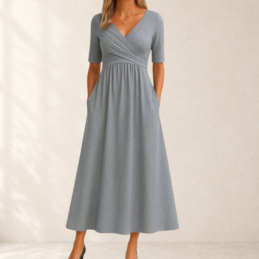 Elegant Phoebe midi dress by THE WHITMORE FAMILY displayed on a mannequin featuring a flowing silhouette and sophisticated design.