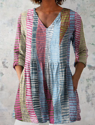 Anais long blouse with V-neck by THE WHITMORE FAMILY, displayed on a model, featuring flowing fabric and elegant design.