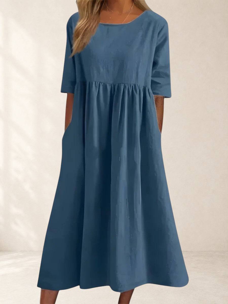 Elegant Cindy dress from THE WHITMORE FAMILY displayed on a hanger with detailed fabric and classic style.