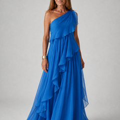 Talia cascading ruffle maxi dress by THE WHITMORE FAMILY, flowing fabric with layered ruffles, worn by a model in a sunny outdoor setting.