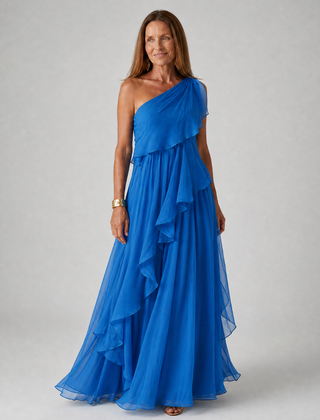 Talia cascading ruffle maxi dress by THE WHITMORE FAMILY, flowing fabric with layered ruffles, worn by a model in a sunny outdoor setting.