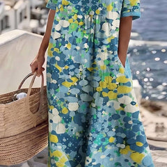 Elegant floral summer midi dress from THE WHITMORE FAMILY, featuring a flowing silhouette and vibrant floral pattern.