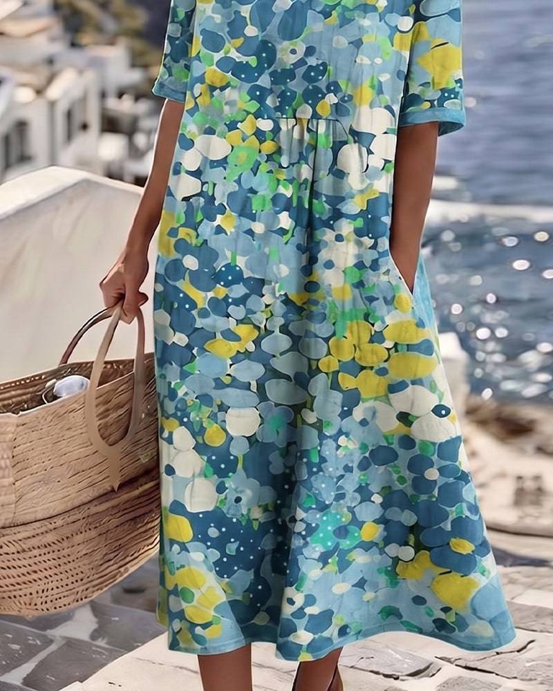 Elegant floral summer midi dress from THE WHITMORE FAMILY, featuring a flowing silhouette and vibrant floral pattern.