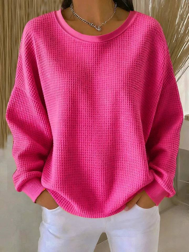Nyla™ Classic Sweater by THE WHITMORE FAMILY, featuring a cozy knit design in a neutral color, displayed on a hanger.
