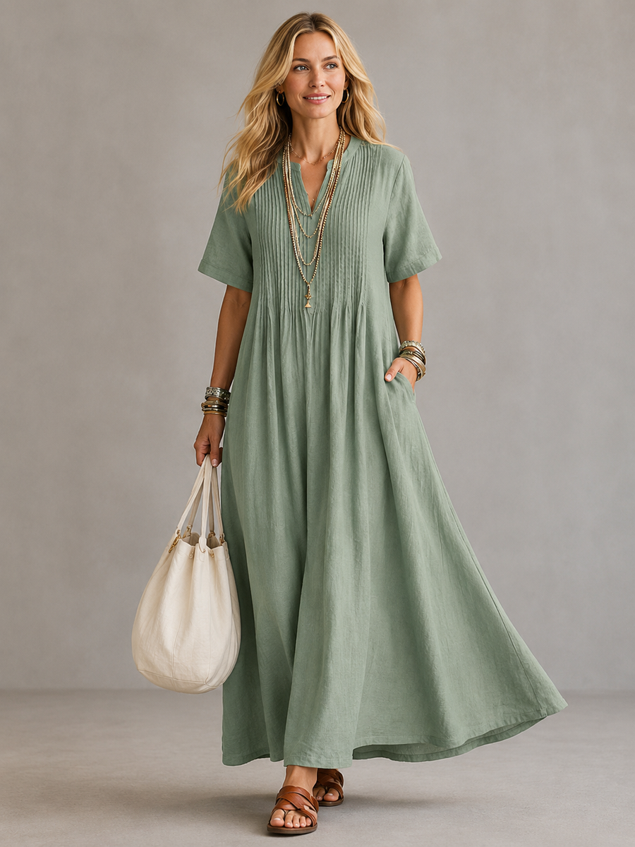 Nathalia™ pleated dress by THE WHITMORE FAMILY, featuring flowing fabric and elegant pleats, shown on a model.