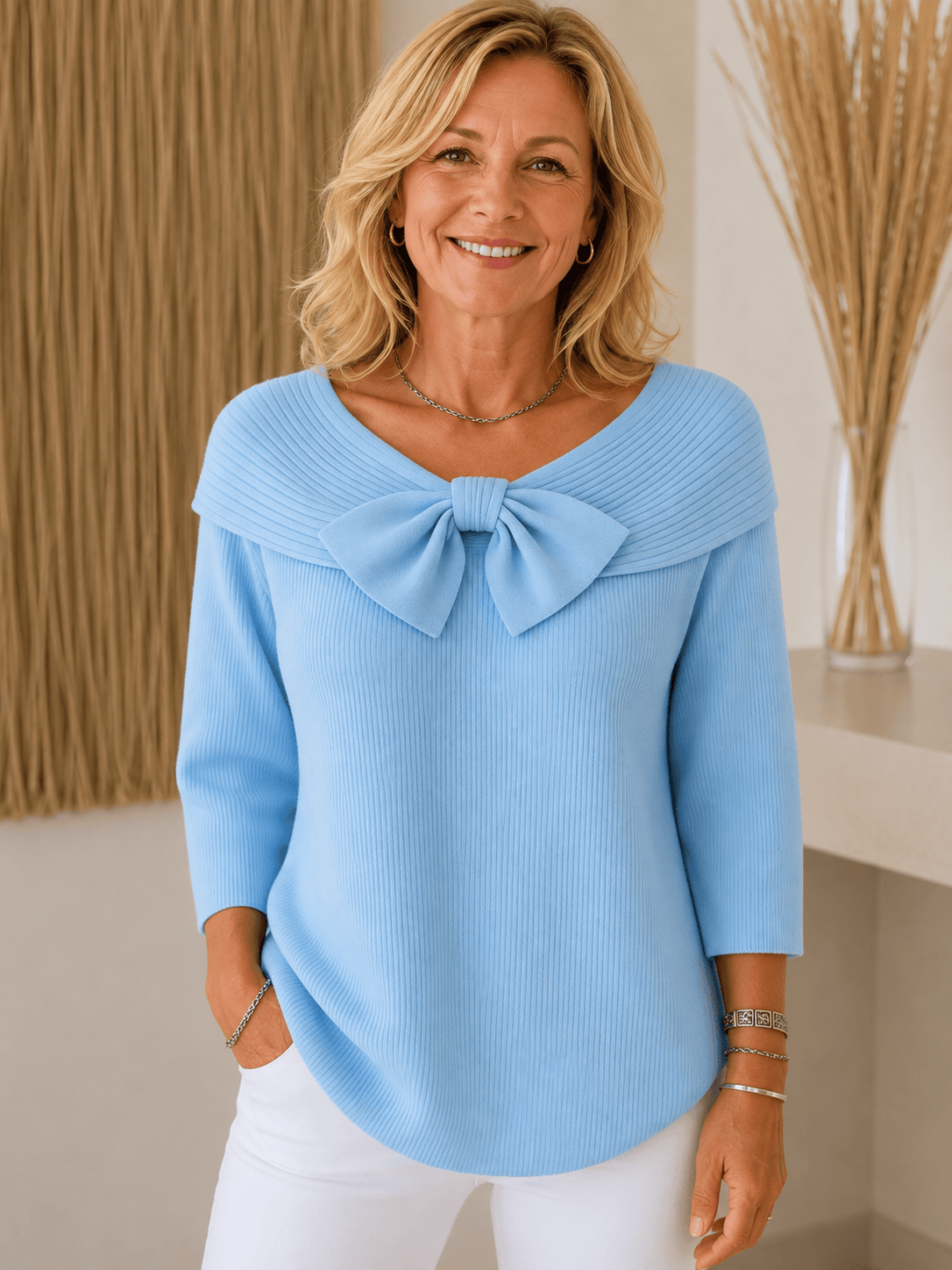 Women's sweater by THE WHITMORE FAMILY featuring a bow detail and round neckline, made of soft knit fabric.