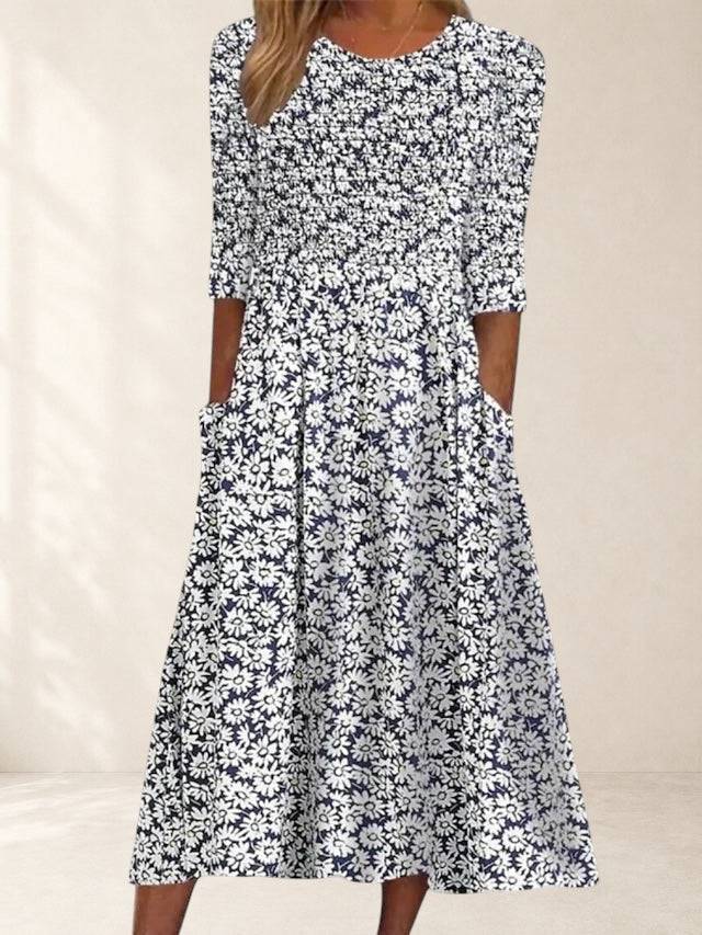 Elegant violet midi dress by THE WHITMORE FAMILY featuring floral pattern and pockets, displayed on a model.