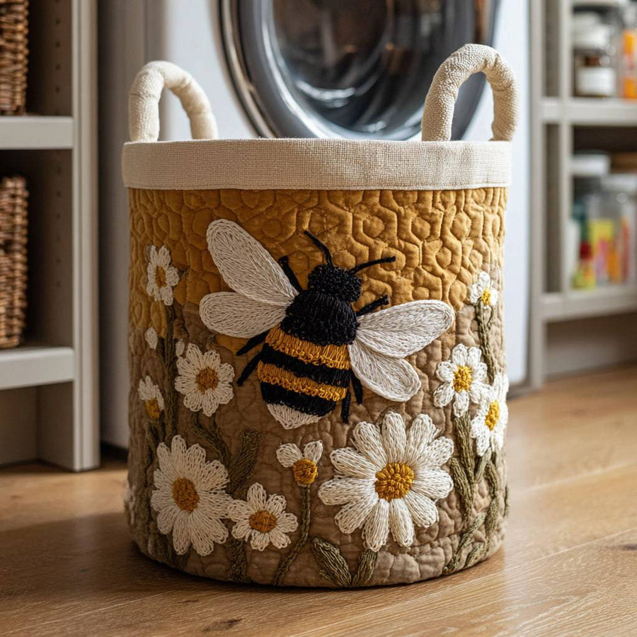 Quilted Daisy Bee Laundry Basket by THE WHITMORE FAMILY, featuring a charming floral and bee design, soft fabric, and sturdy handles.