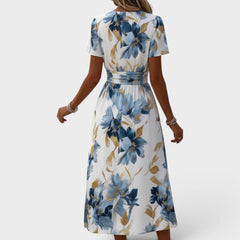 Denise floral wrap waist midi dress from THE WHITMORE FAMILY featuring a flowing fabric and elegant floral pattern.