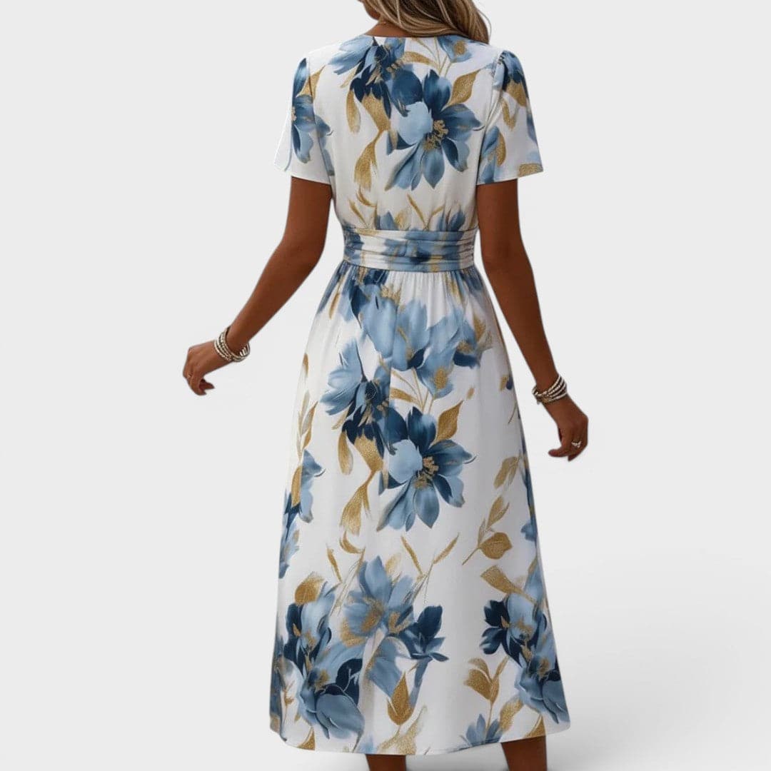 Denise floral wrap waist midi dress from THE WHITMORE FAMILY featuring a flowing fabric and elegant floral pattern.