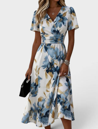 Floral wrap midi dress by THE WHITMORE FAMILY featuring a waist tie and a vibrant floral pattern, showcased on a model.