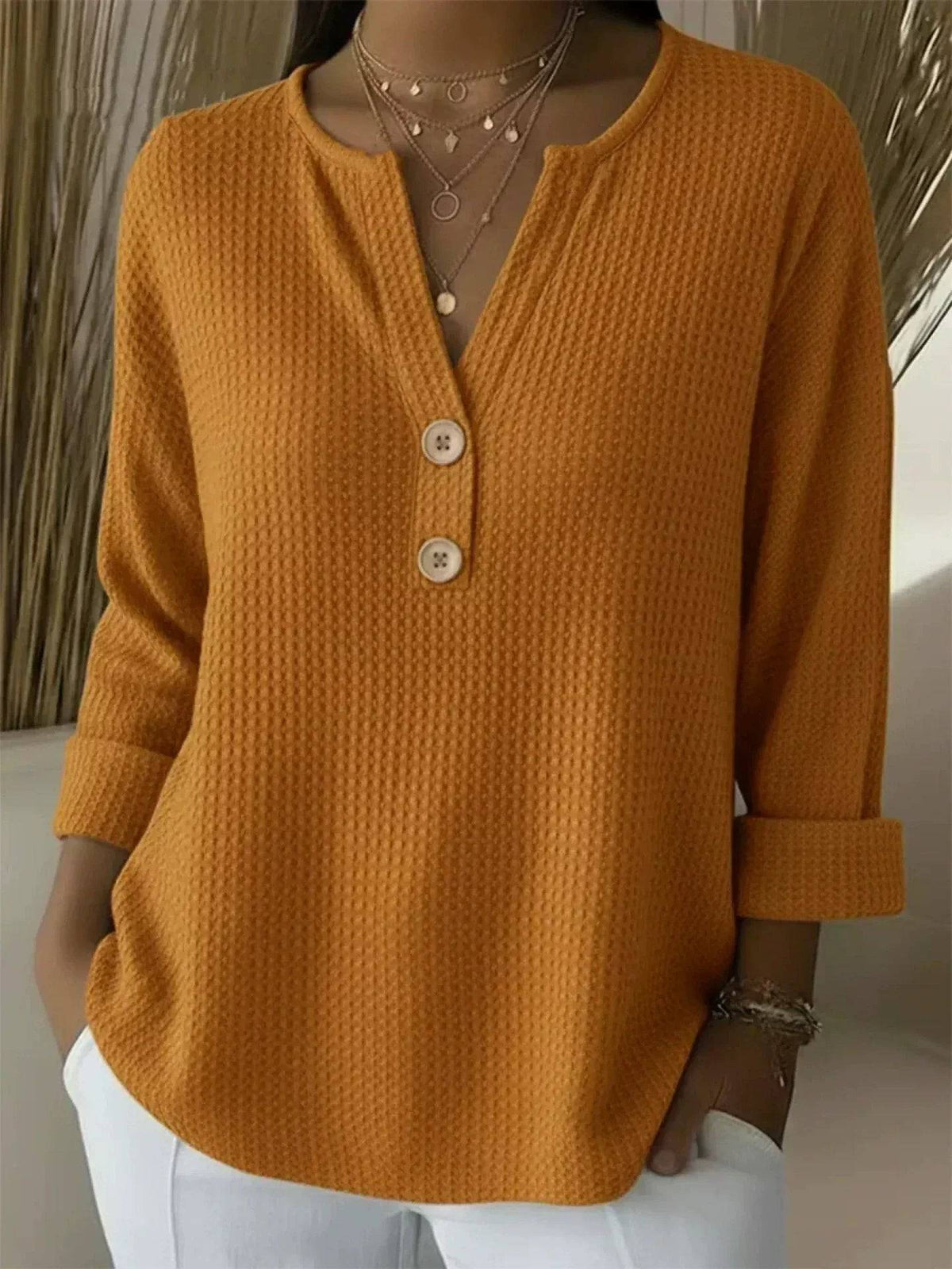 Orange women's Henley button top sweater by THE WHITMORE FAMILY, featuring a cozy knit design and buttoned front.
