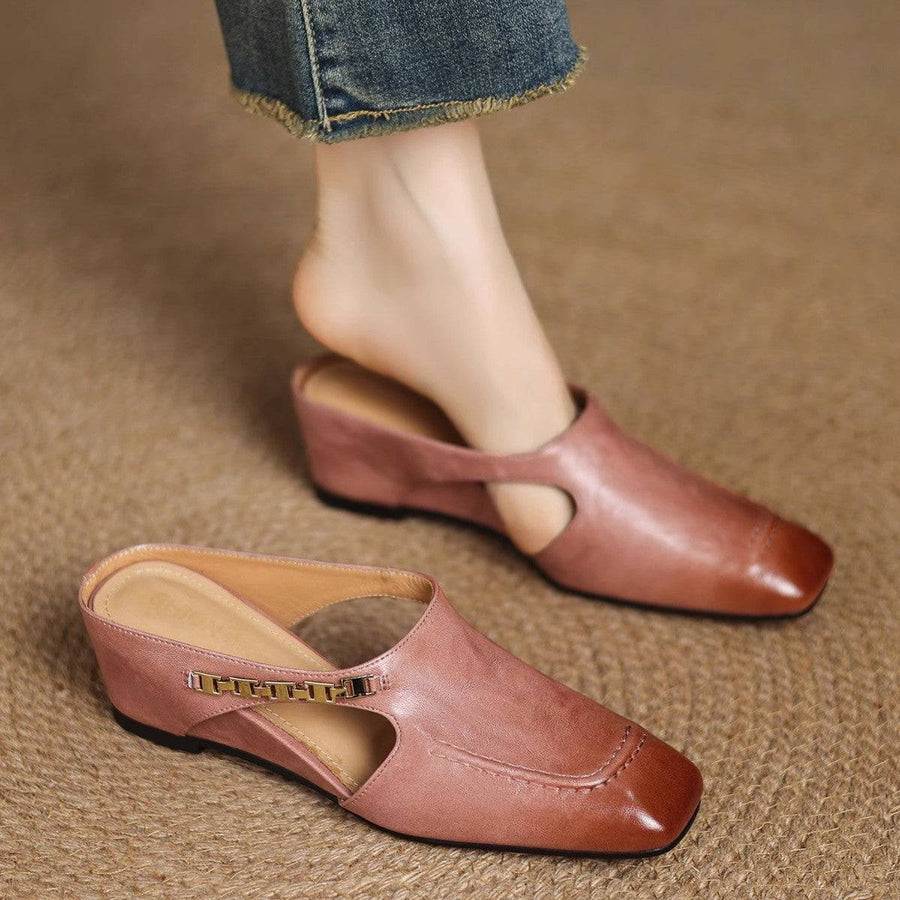 Pair of black Avella Leather Mules by THE WHITMORE FAMILY featuring sleek leather design and pointed toe on a white background.