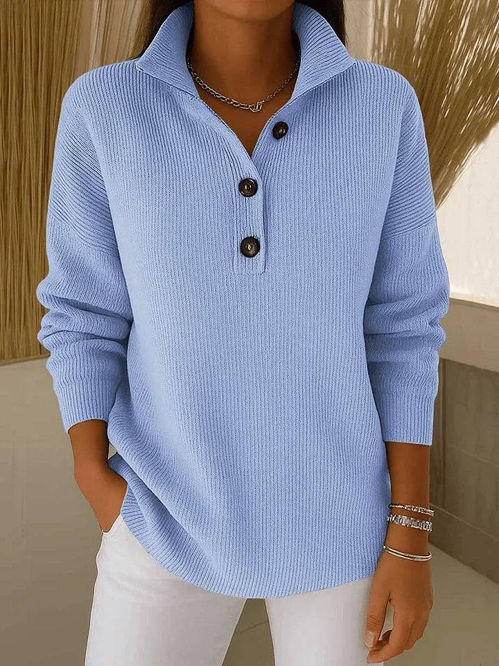 PhoebeBlue Florence™ V-Neck Polo Sweater by THE WHITMORE FAMILY, featuring a soft blue knit fabric and classic V-neck design.
