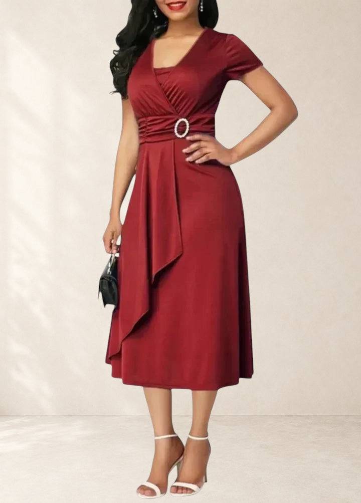 Elegant midi dress by THE WHITMORE FAMILY featuring a fitted bodice and flowing skirt, displayed on a neutral background.