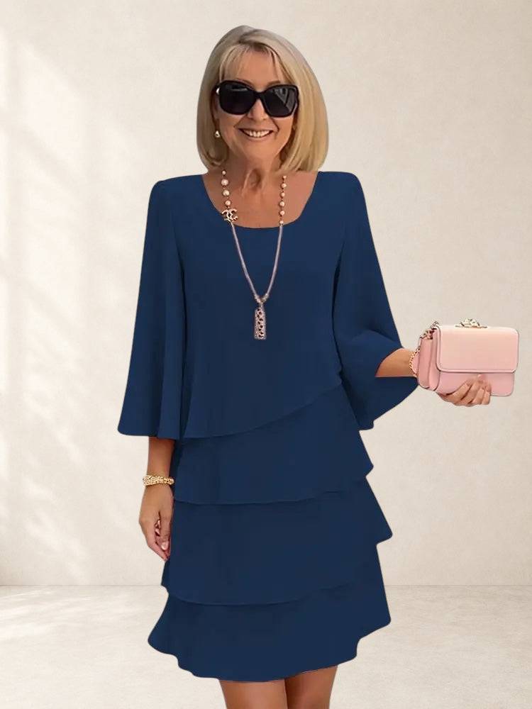 Elegant Comfort Catherine ruffle dress by THE WHITMORE FAMILY, featuring a flowing silhouette and delicate ruffle details.