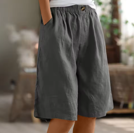 Louise Everyday Elegance Shorts by THE WHITMORE FAMILY, beige linen shorts with a relaxed fit and high waist, displayed on a model.