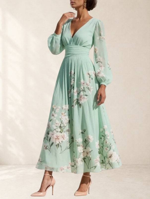 Light green Mathilda V-neck chiffon pleated floral midi dress by THE WHITMORE FAMILY, shown with flowy fabric and floral pattern.