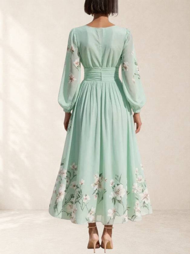 Light green Mathilda chiffon pleated floral midi dress with V-neck from THE WHITMORE FAMILY, shown on a model.