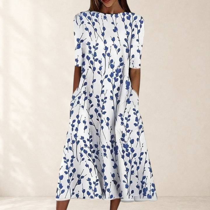 Elegant Sarah midi dress by THE WHITMORE FAMILY displayed on a hanger with soft fabric details and subtle color tones.