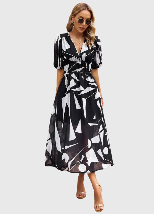 Flattering floral midi dress by THE WHITMORE FAMILY featuring a fitted waist and vibrant floral pattern, perfect for spring and summer.