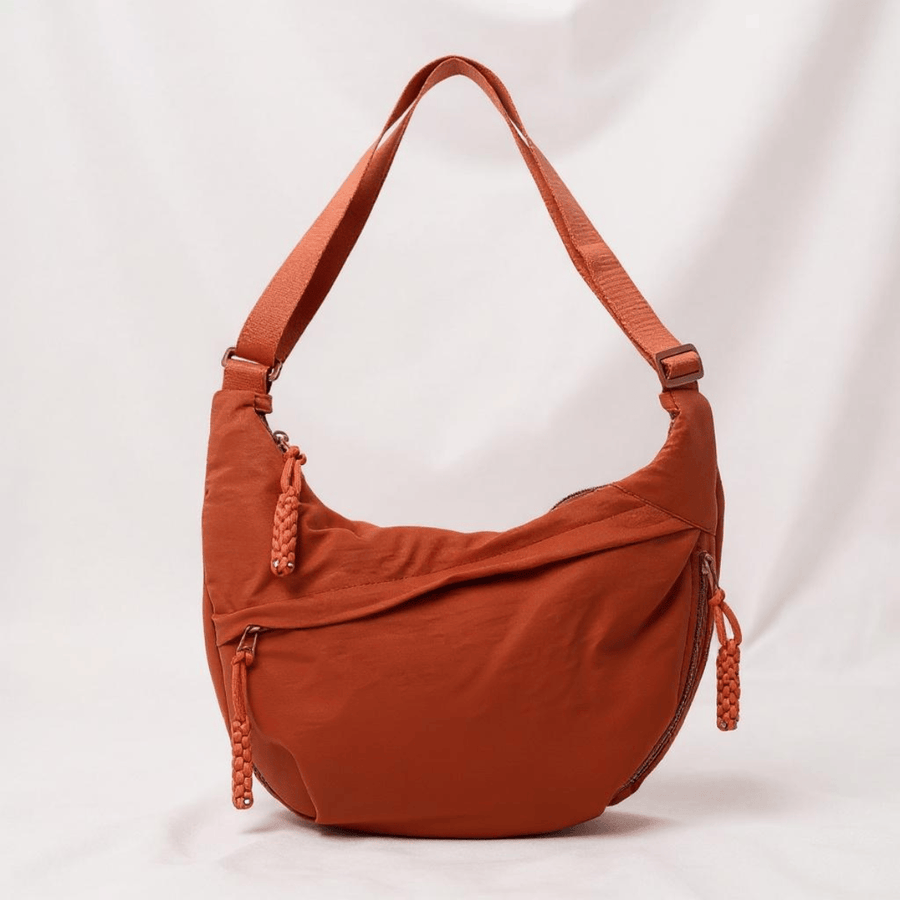 Orange shoulder bag by THE WHITMORE FAMILY, Gioia model, featuring a stylish design with a shoulder strap and vibrant color.