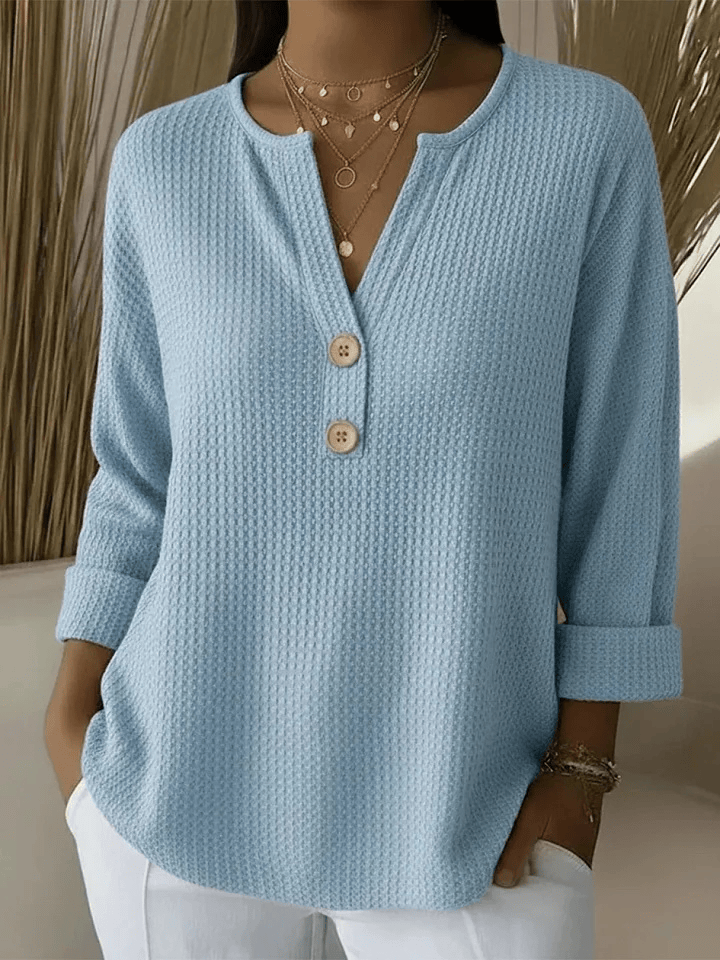 Lucinda™ Henley Button Top by THE WHITMORE FAMILY, featuring a classic button-up design in soft fabric, displayed on a hanger.