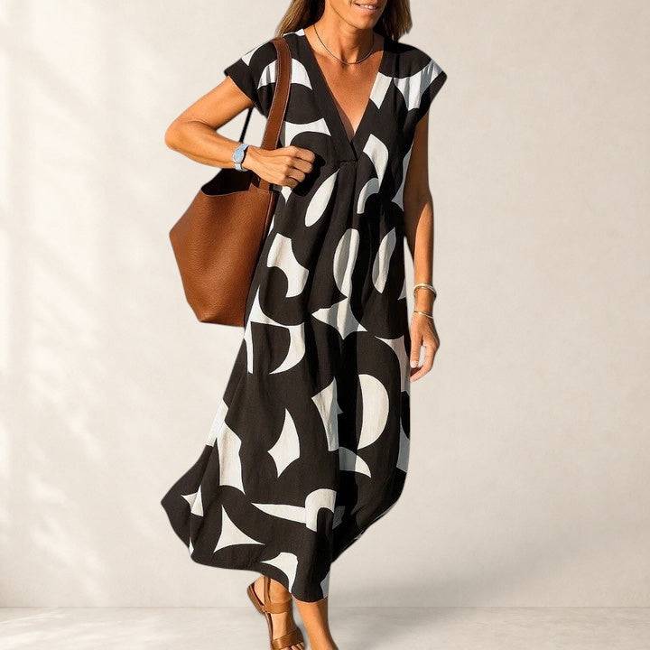 Flowing V-neck dress by THE WHITMORE FAMILY, lightweight fabric, elegant fit, with a flowing silhouette and V-neckline.