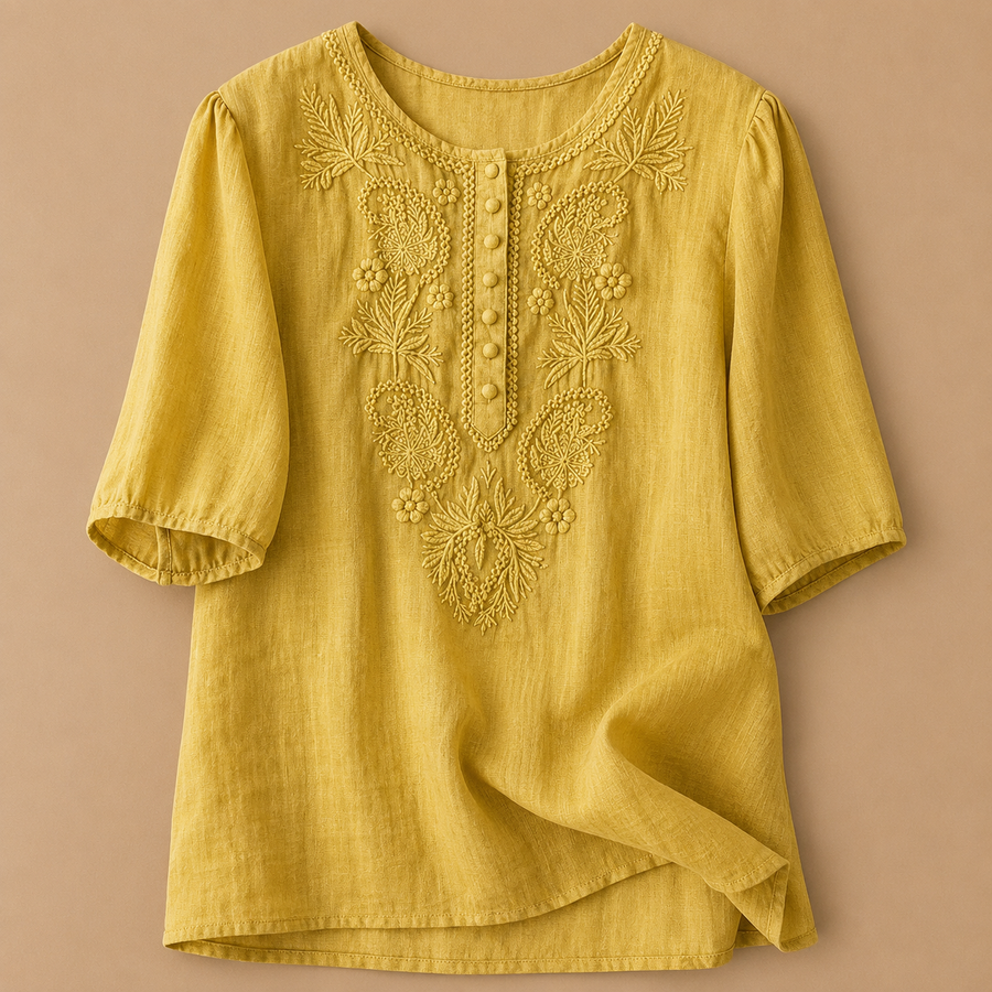 Light-colored Verena Cotton Linen Blouse by THE WHITMORE FAMILY with shirr detailing, shown on a hanger.