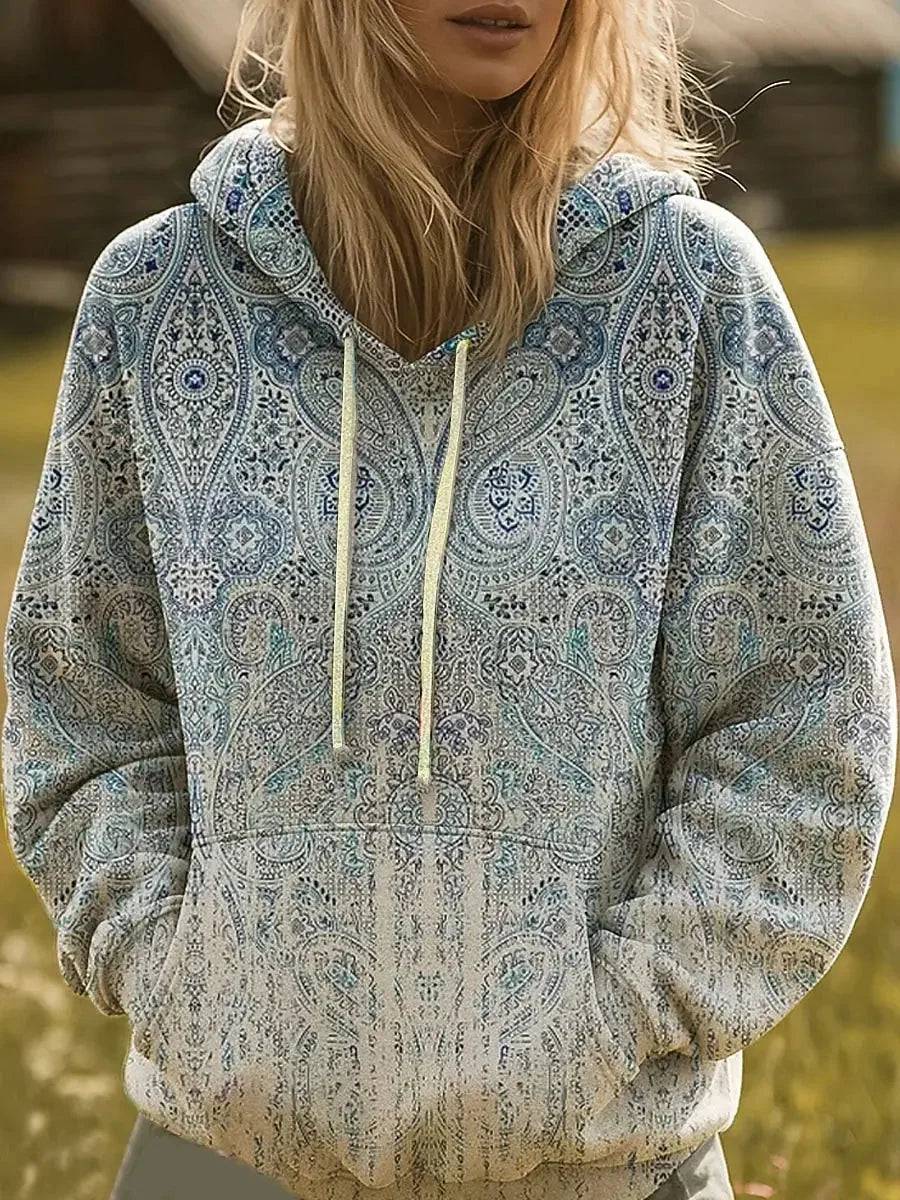 The Silvia Paisley Hoodie by THE WHITMORE FAMILY features a paisley print sweater with a hood and long sleeves.