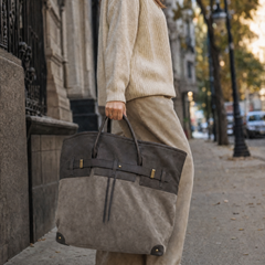 The Juliette Suede Tote bag by THE WHITMORE FAMILY, shown in a stylish lifestyle setting with soft suede material and spacious design.