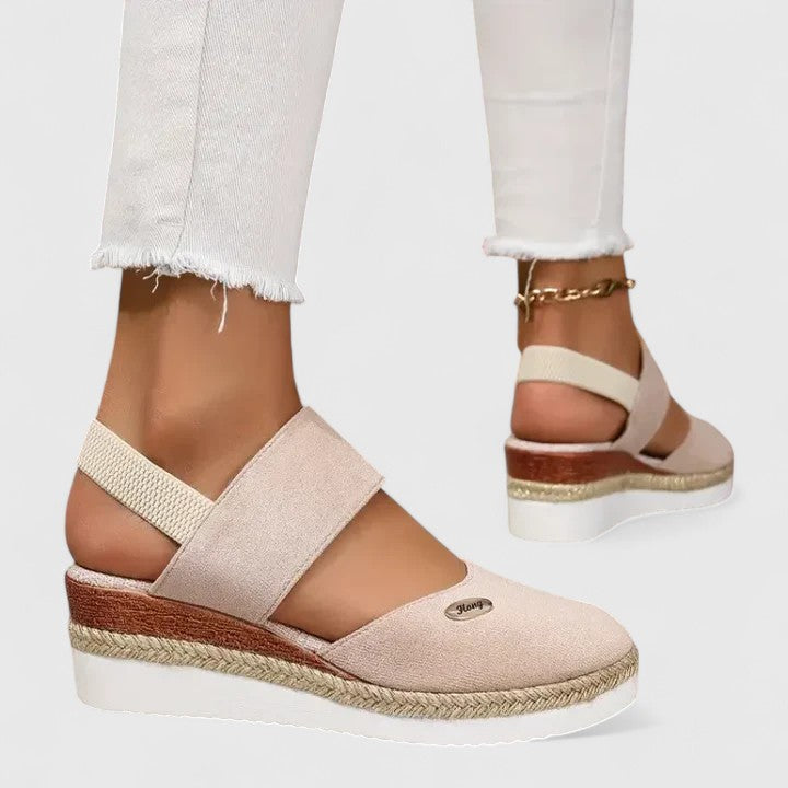 Beige Maylien™ orthopedic sandals from THE WHITMORE FAMILY with adjustable straps and cushioned soles, designed for comfort.