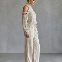 Beige open shoulder knit top and wide-leg pants set from THE WHITMORE FAMILY, styled for a casual yet elegant look.