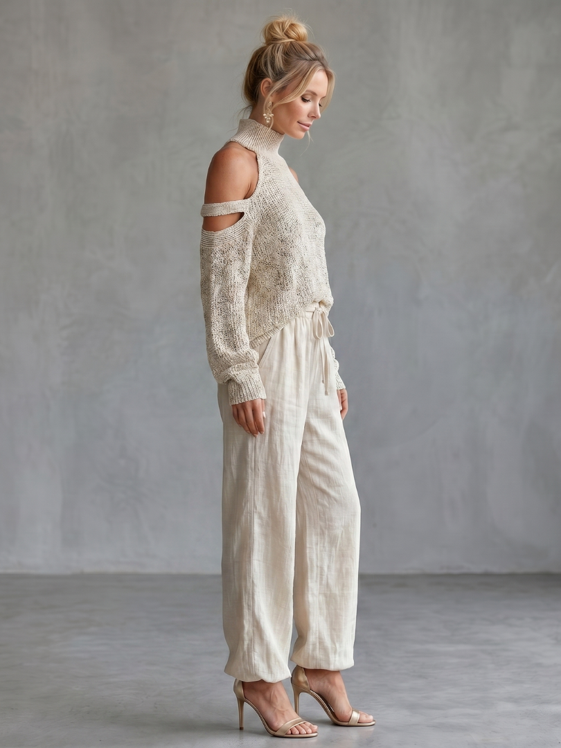 Beige open shoulder knit top and wide-leg pants set from THE WHITMORE FAMILY, styled for a casual yet elegant look.