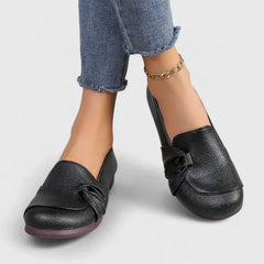 Black Ivarynn elegant shoes by THE WHITMORE FAMILY, featuring a sleek design with pointed toes and stylish detailing.