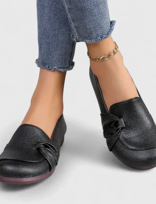 Black Ivarynn elegant shoes by THE WHITMORE FAMILY, featuring a sleek design with pointed toes and stylish detailing.