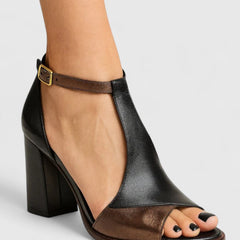 Black Kenzira modern heels by THE WHITMORE FAMILY featuring sleek design and pointed toes on a white background.