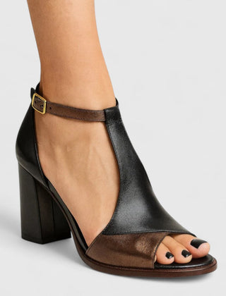 Black Kenzira modern heels by THE WHITMORE FAMILY featuring sleek design and pointed toes on a white background.