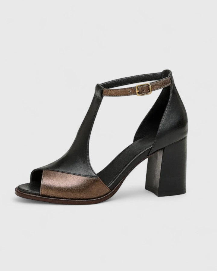 Black Kenzira modern heels by THE WHITMORE FAMILY, featuring sleek design and pointed toes on a white background.