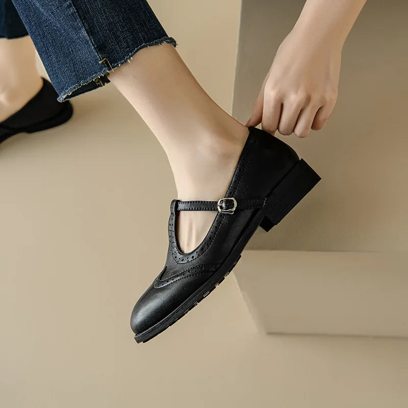 Black Patricia T-strap Mary Janes by THE WHITMORE FAMILY, featuring elegant design and classic footwear style.