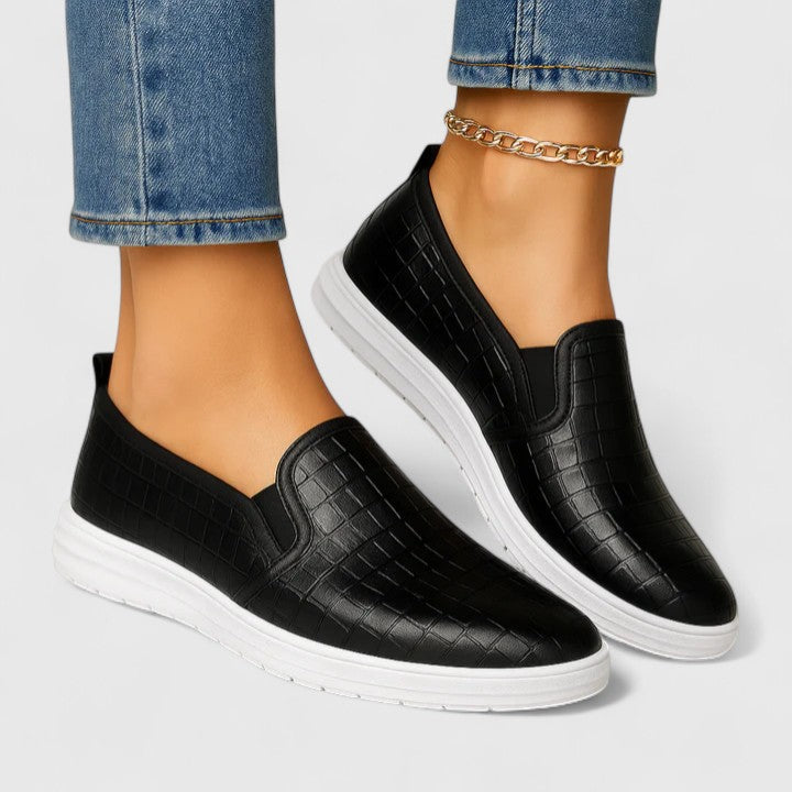 Black Zhielle Supportive Style Loafers by THE WHITMORE FAMILY, shown from a side angle on a white background.