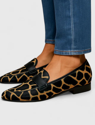 Black and gold Kleirra Timeless Loafers by THE WHITMORE FAMILY, showcasing sleek leather design and classic style.