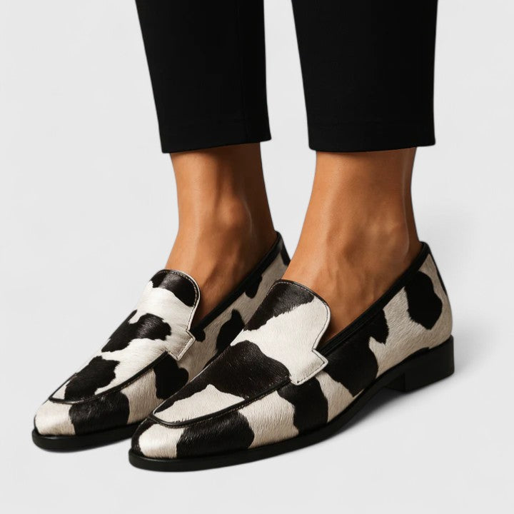Black Quinzee Cushioned Elegance Loafers by THE WHITMORE FAMILY, showcasing comfortable slip-on footwear with a sleek design.