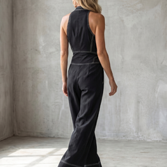 Black Dara jumpsuit by THE WHITMORE FAMILY featuring a zip front, contrast stitching, and wide-leg design.
