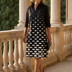Black Faye Evening Walk Dress by THE WHITMORE FAMILY, featuring elegant fabric and a stylish silhouette, displayed on a hanger.