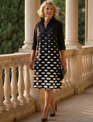 Black Faye Evening Walk Dress by THE WHITMORE FAMILY, featuring elegant fabric and a stylish silhouette, displayed on a hanger.