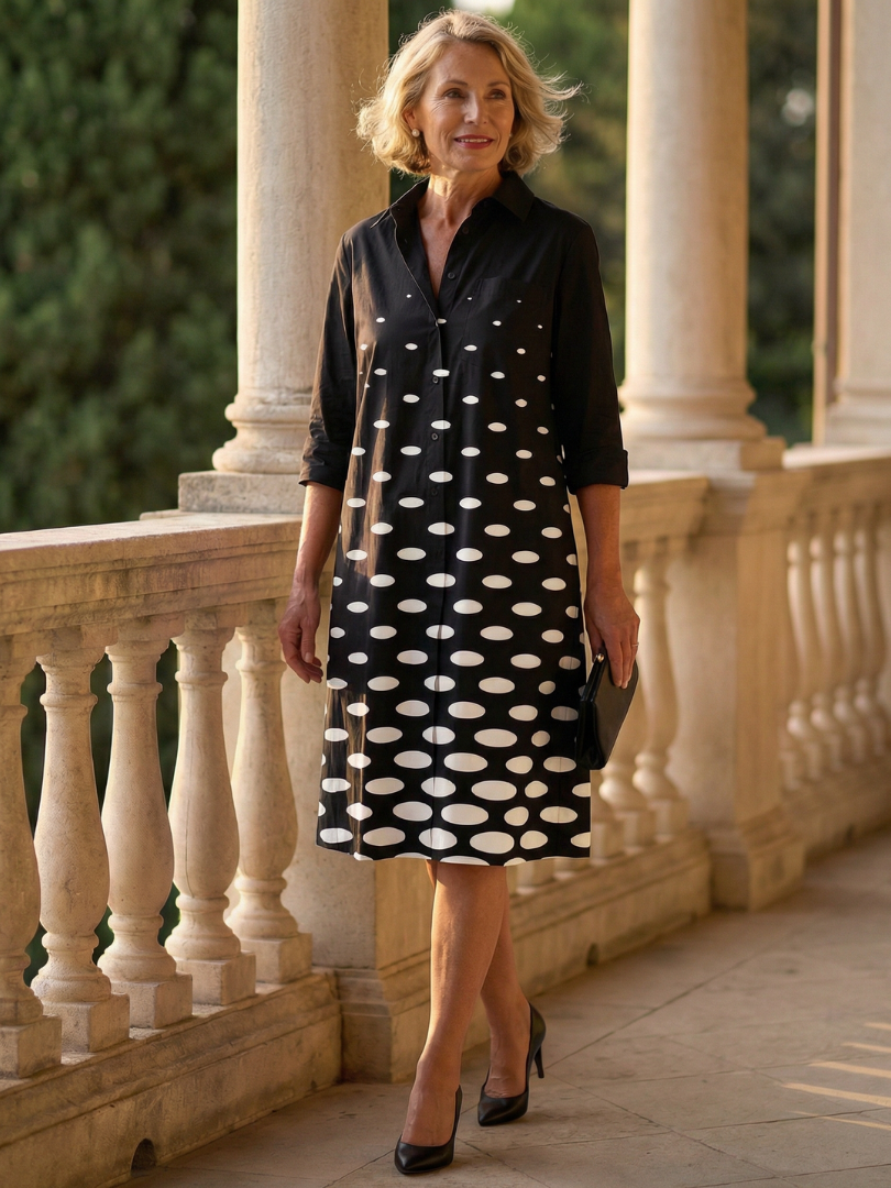 Black Faye Evening Walk Dress by THE WHITMORE FAMILY, featuring elegant fabric and a stylish silhouette, displayed on a hanger.