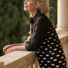 Black Faye Evening Walk Dress by THE WHITMORE FAMILY displayed on a hanger, showcasing its elegant design and fabric texture.